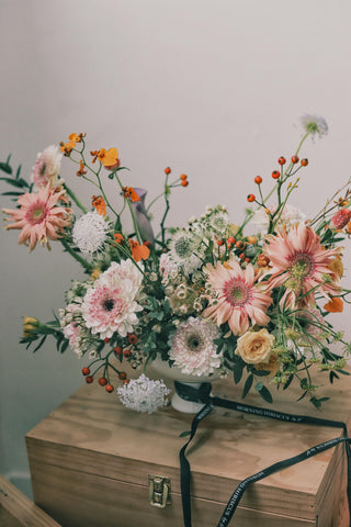 Colorful bouquet with pink and white flowers on a wooden box