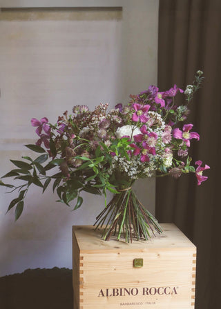 Colorful bouquet with purple and green flowers on a wooden box