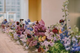 Colorful floral arrangement with various blooms displayed on a table.