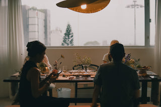 People dining at a table with floral arrangements